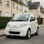 Aixam électrique blanche d'occasion garée dans une rue résidentielle française, vue trois quarts avant