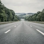 Autoroute française gratuite avec marquages au sol clairs et arbres bordant la route, perspective fuyante sans péage