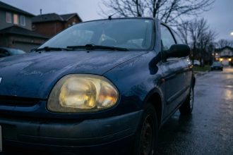 Phares jaunis et oxydés d'une Renault Clio 2 ancienne, visibilité nocturne réduite par l'usure des optiques