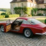 Voiture de collection italienne des années 60 restaurée garée devant un manoir en pierre, illustrant l'assurance voiture de collection